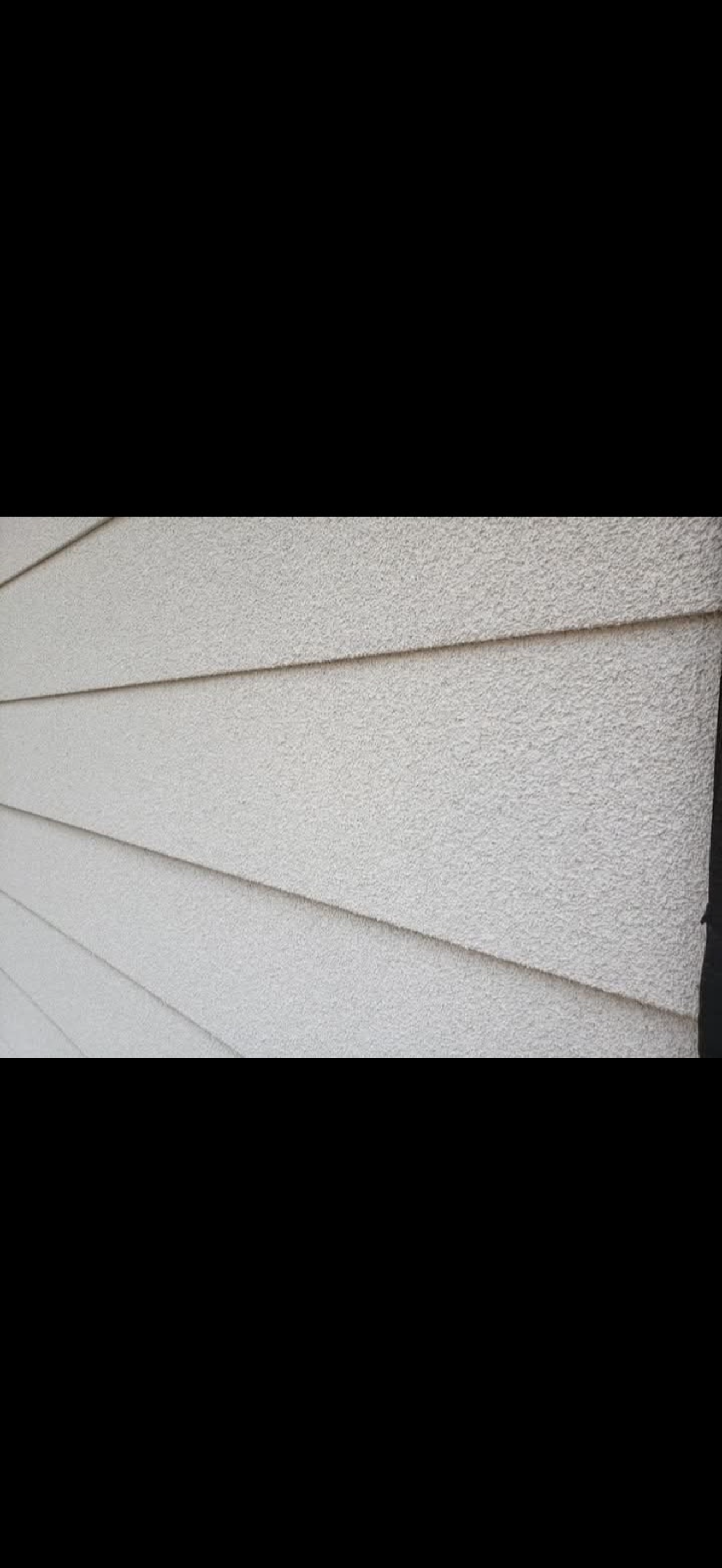 Close view of a light textured cork coating on siding
